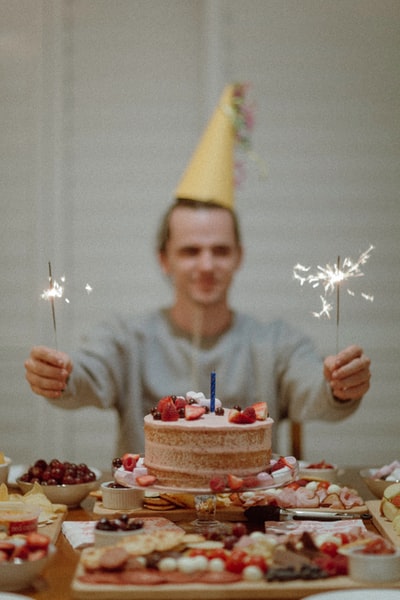 在蛋糕之间拿着火花的人的选择性聚焦摄影